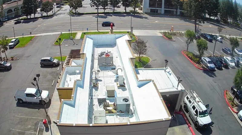 Aerial view of a commercial roof replacement in progress with crew and equipment in Burbank